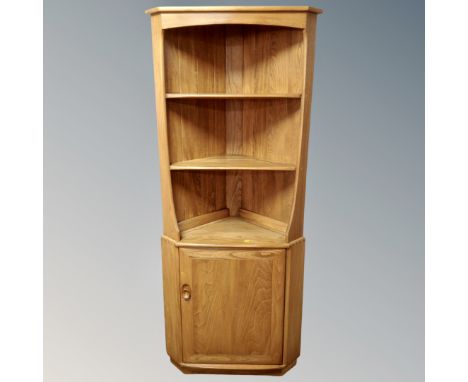 An Ercol elm and beech Windsor open corner unit fitted with cupboard below 