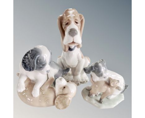 A Nao figure of a seated hound together with two further Nao figure groups, playful puppies.