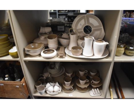 A large collection of Poole Pottery in fawn and coffee colour way, including toast rack, cups and saucers, platter, bowls and