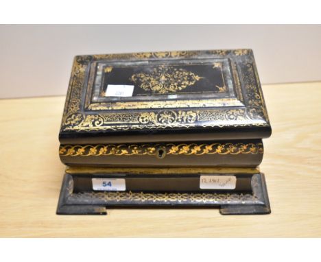 An early 19th Century black lacquered papier mache tea caddy, of sarcophagus form and decorated in gilt, measuring 13cm tall,