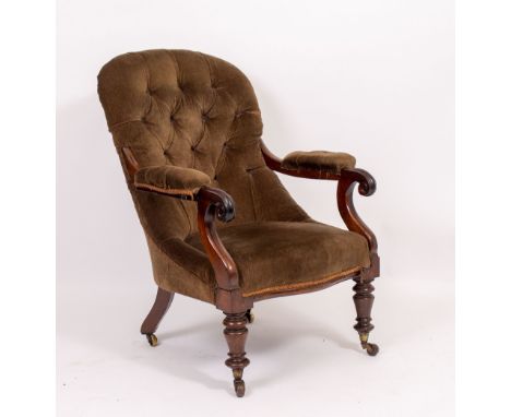 A VICTORIAN ROSEWOOD FRAMED, BUTTON UPHOLSTERED LIBRARY ARMCHAIR with turned front legs and brass casters, 70cm wide x 75cm d