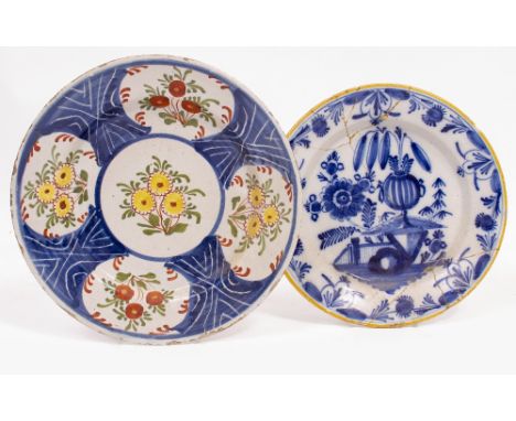 AN ANTIQUE DUTCH DELFT POLYCHROME TIN GLAZED PLATE decorated with flowers, 26cm diameter together with a further delftware pl