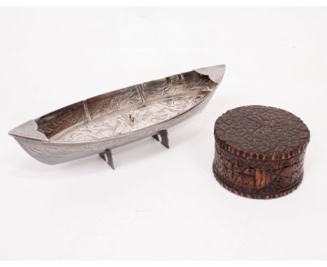 A MARKED WHITE METAL NOVELTY BOAT with engraved decoration standing on two feet, a treen possibly bamboo carved circular box,