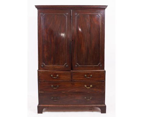A 19TH CENTURY MAHOGANY LINEN PRESS with twin panelled doors above two short and two long drawers with brass swan neck handle
