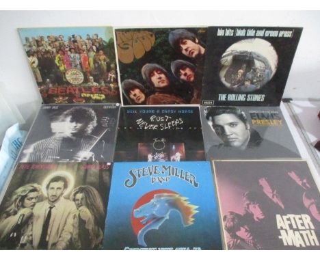 A collection of 12" vinyl records including The Beatles, The Rolling Stones, Jimmy Page, Neil Young, Simon &amp; Garfunkel, B