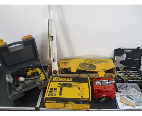 A collection of various tools and accessories including a DeWalt drill, DeWalt sander, battery charger, saw, drill bits etc