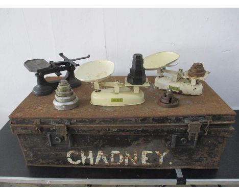Three vintage sets of scales with weights, along with a metal trunk.