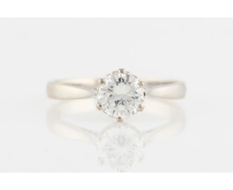 A diamond solitaire ring, set with a round brilliant cut diamond, measuring approx. 0.80ct, with tapered raised shoulders, st