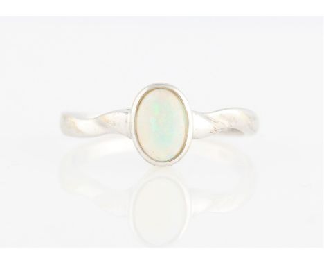 An opal ring, set with an oval opal cabochon, measuring approx. 5x7mm, stamped 585, ring size M½.