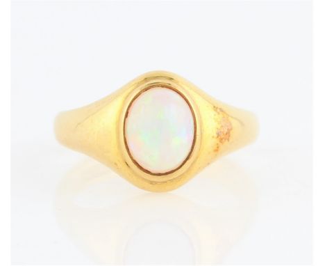 An opal single stone ring, bezel set with an oval opal cabochon, measuring approx. 7x6mm, with tapered shoulders, stamped 18c