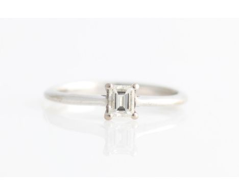 A hallmarked 18ct white gold diamond solitaire ring, set with an emerald cut diamond, measuring approx. 0.25ct, ring size I.