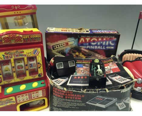 A selection of various toys including atomic pinball, super slot triple thunder mini fruit machine, Schweizer 300 helicopter,