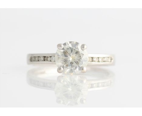A hallmarked 9ct white gold moissanite ring, set with a central round cut moissanite, measuring approx. 0.85ct, channel set w
