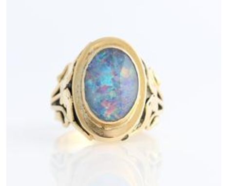 An opal doublet ring, set with an oval opal doublet measuring approx. 14x9mm, with open metalwork scroll design shoulders, st