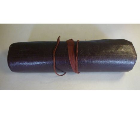 A late Victorian maroon hide clad traveller's writing case, the hinged lid enclosing an inkwell and pen tray, wrapped in a fo