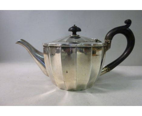 A late Victorian bachelor's silver teapot of fluted bowl design, having an ebonised handle and knop to the hinged lid  Hukin 