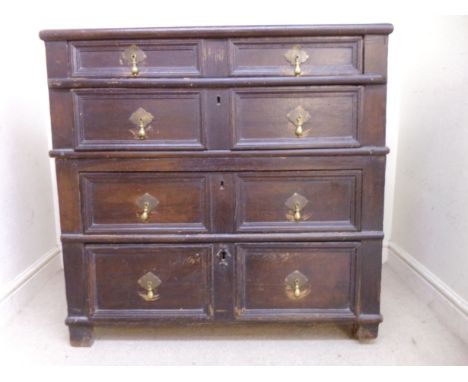An early 18thC oak two section dressing chest, having a planked top, over four graduated long drawers, each with moulded pane