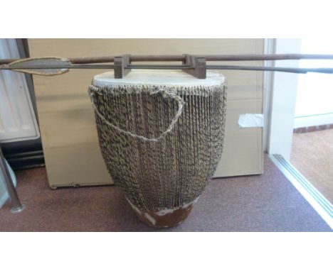 A Ugandan stretched hide drum  17''h and a double ended metal spear, having a flat head to one end and long narrow point to t
