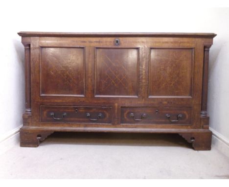 A George III mahogany veneered and oak chest, having a rising top, enclosing two drawers, over a tri-panelled marquetry front