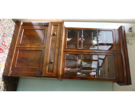 An early Victorian flame veneered mahogany cabinet bookcase, having a moulded cornice, over a pair of glazed doors, enclosing