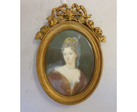 An 18th/19thC head and shoulders oval portrait miniature, Mme La Duchesse du Maine wearing a bejewelled headdress, a white la