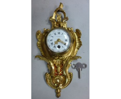 A late 19thC French cartel design gilt metal cased wall clock, the backplate cast with ornate swags and flora; the 8 day move