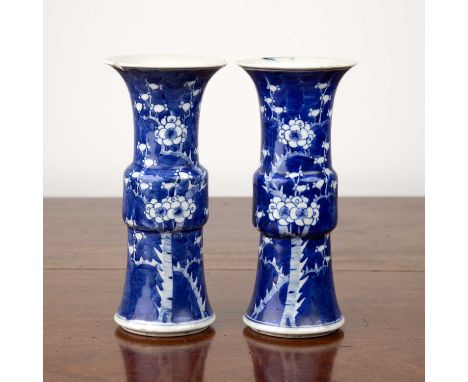 Pair of blue and white porcelain Gu-shaped vasesChinese, 19th Century, each with prunus decoration and Kangxi six-character m