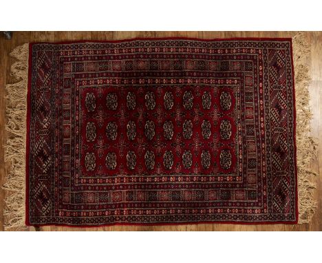Red ground rugPakistan, with a panel of elephant foot designs, 121cm x 172cmWith some light wear.