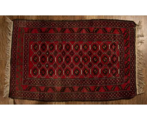  Red ground wool rugwith geometric designs and stylised leaf border, 151cm x 89cm With light wear.