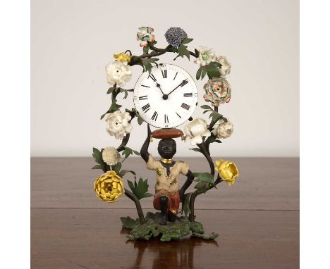 Porcelain, glass and blackamoor mantel clockthe kneeling figure supporting an enamel clock face, beneath trailing floral surr