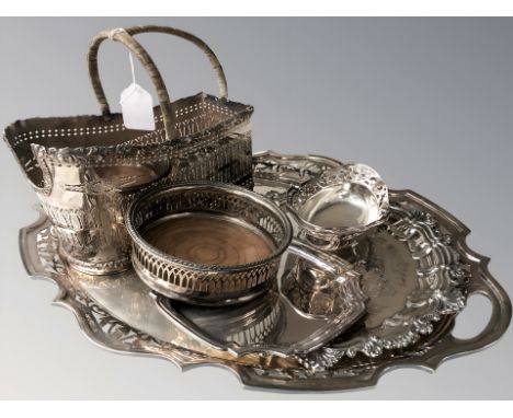 An EPNS pierced twin handled serving platter, two others smaller, a swing handled basket, a bottle coaster and a further EPNS