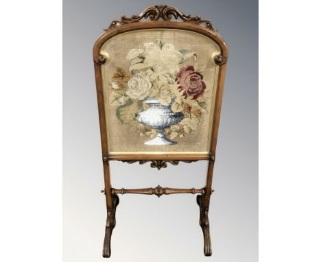 A Victorian carved walnut tapestry fire screen, height 104 cm.