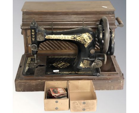A Singer hand sewing machine in box.