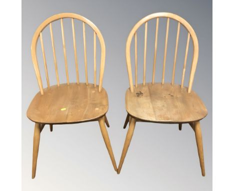 A pair of Ercol elm and beech spindle back dining chairs.