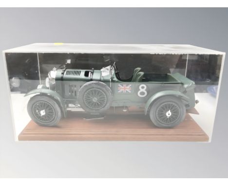 A plastic scale model of a 1930 Bentley, on wooden plinth, under perspex cover, length 39 cm.