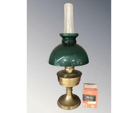 A brass Aladdin oil lamp with green glass shade and clear chimney, height 61 cm.