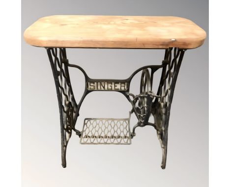 A cast iron Singer treadle sewing machine base with pine top, width 77 cm.