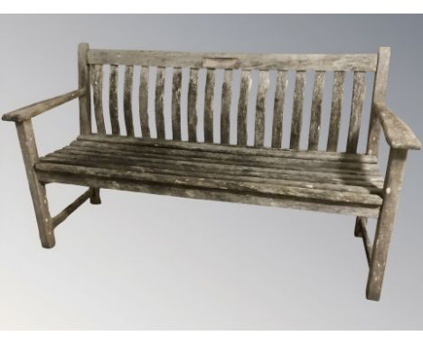 A weathered Alexander Rose teak garden bench, length 151 cm.