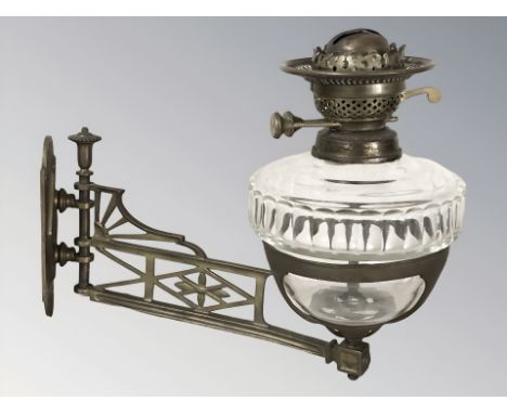 A Victorian oil lamp with brass mounting bracket, length 38 cm.