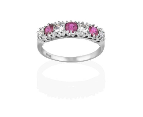four round brilliant cut diamonds alternate with three round cut rubies, in white claw settings, to a tapered shoulder plain 