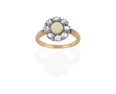 the round cabochon opal within a border of rose cut diamonds, in white claw settings, to a yellow tapered shoulder plain poli