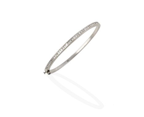 the tapered square-cut diamonds in a white channel setting, to a plain polished hinged back, total estimated diamond weight 1