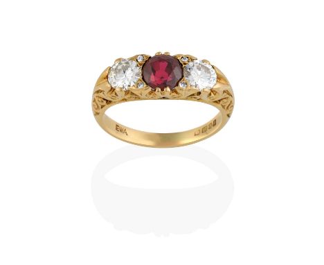 the round cut synthetic ruby flanked by round brilliant cut diamonds, with eight-cut diamond accents, in yellow claw settings