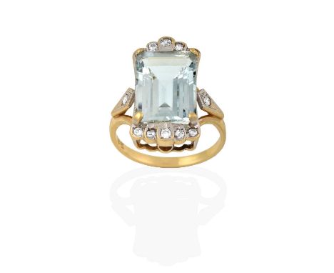 the emerald-cut aquamarine in a yellow claw setting, flanked by five round brilliant cut diamonds, in white rubbed over setti