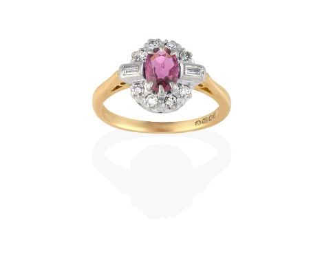 the oval cut ruby within a border of eight-cut diamonds, with baguette cut diamonds set above the shoulders, in white claw an