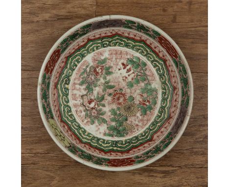 Wucai shallow dishChinese, Kangxi period (1662-1722)painted with a central panel of flowers on a checkered ground, within a r