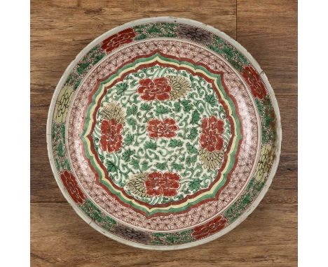 Wucai large shallow bowl/chargerChinese, Kangxi period (1662-1722)painted with a central lotus panel of peonies, within a dia