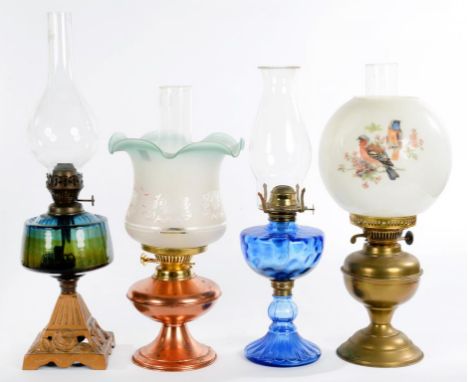 A LATE VICTORIAN CAST IRON OIL LAMP WITH GLASS FOUNT AND THREE OTHER OIL LAMPS, VARIOUS SIZES