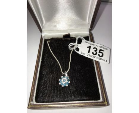 A diamond and blue stone pendant set in 9ct gold with attached chain.