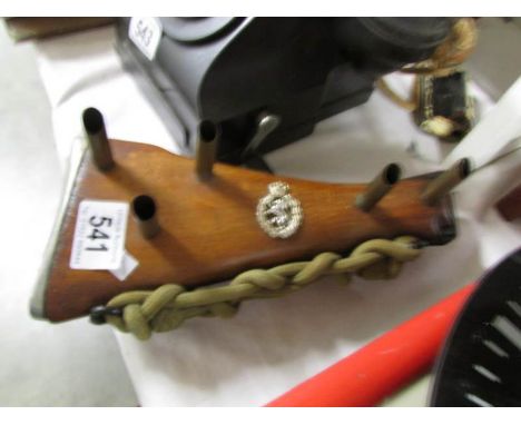 An item of war memorabilia being a rifle stock with regimental badge made in to a stand.